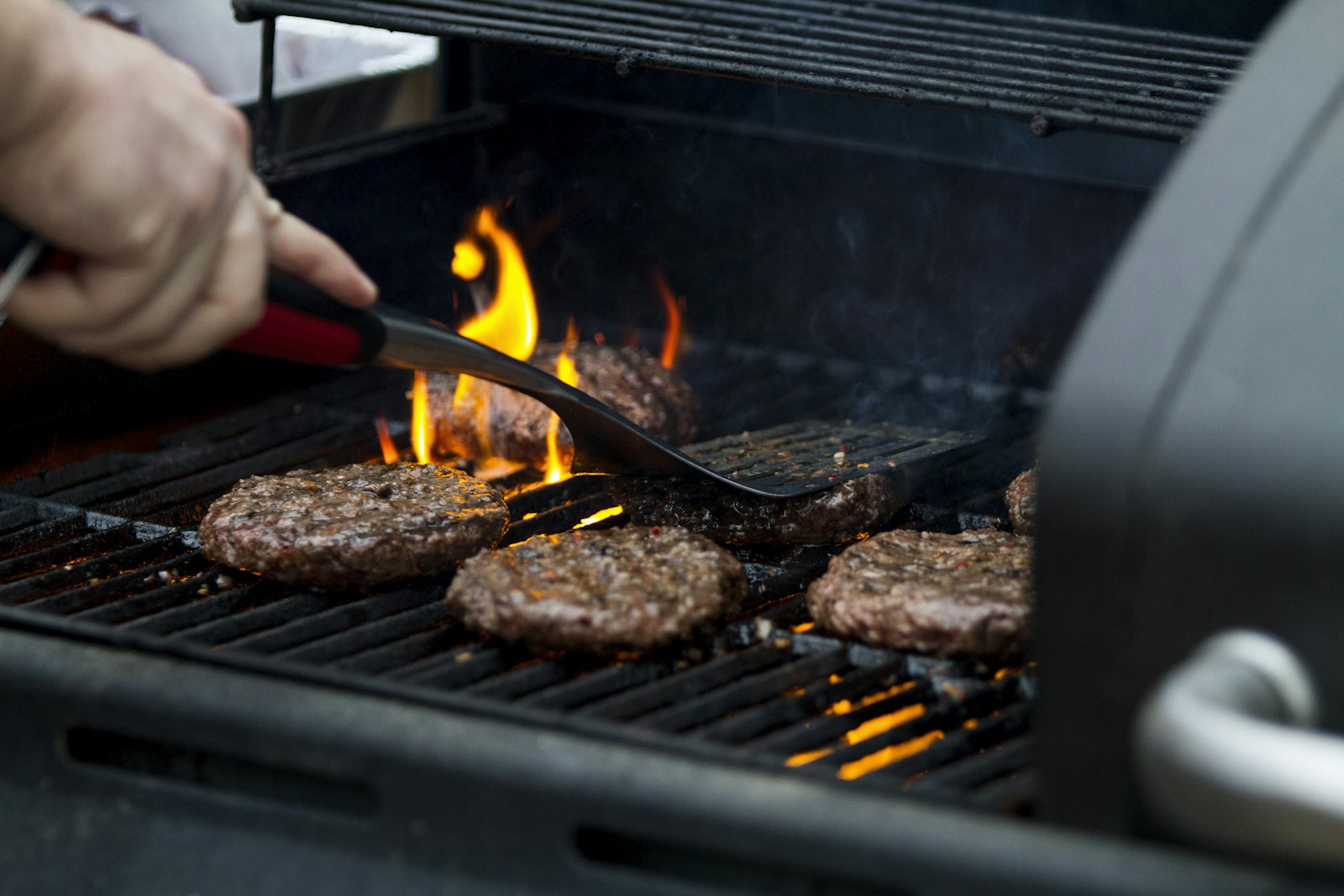 Burger-Patties auf einem Grill über offenem Feuer
