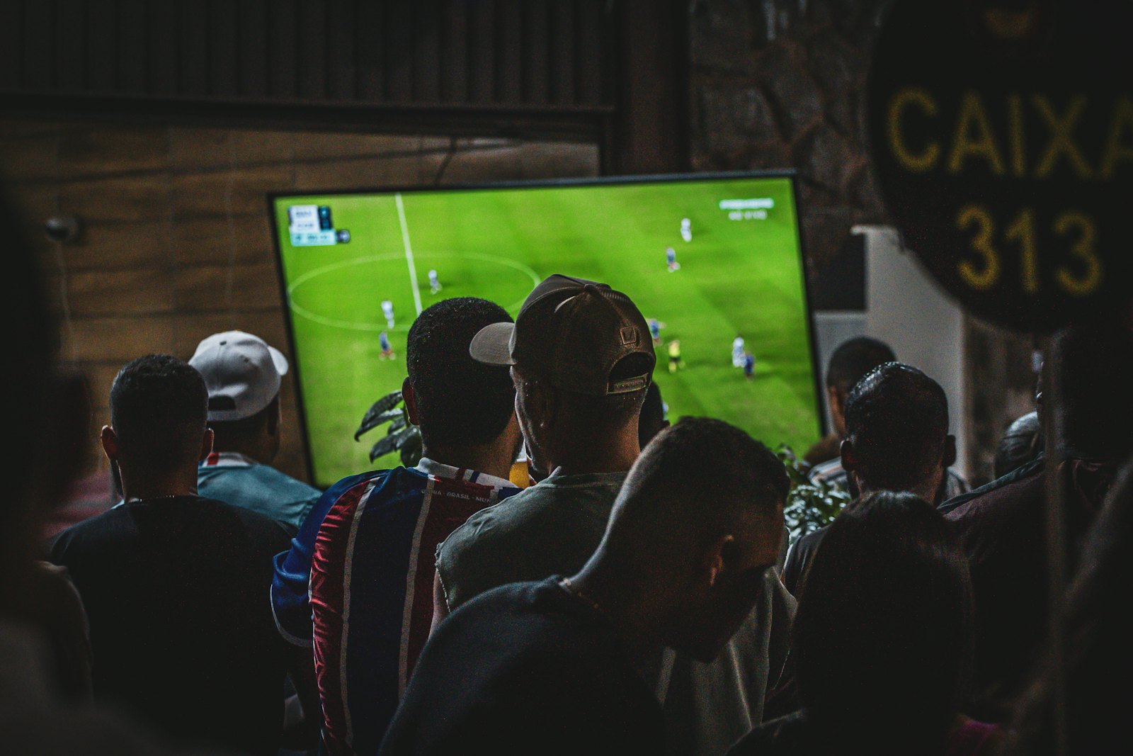 Freunde schauen ein Fußballspiel auf einem großen Bildschirm