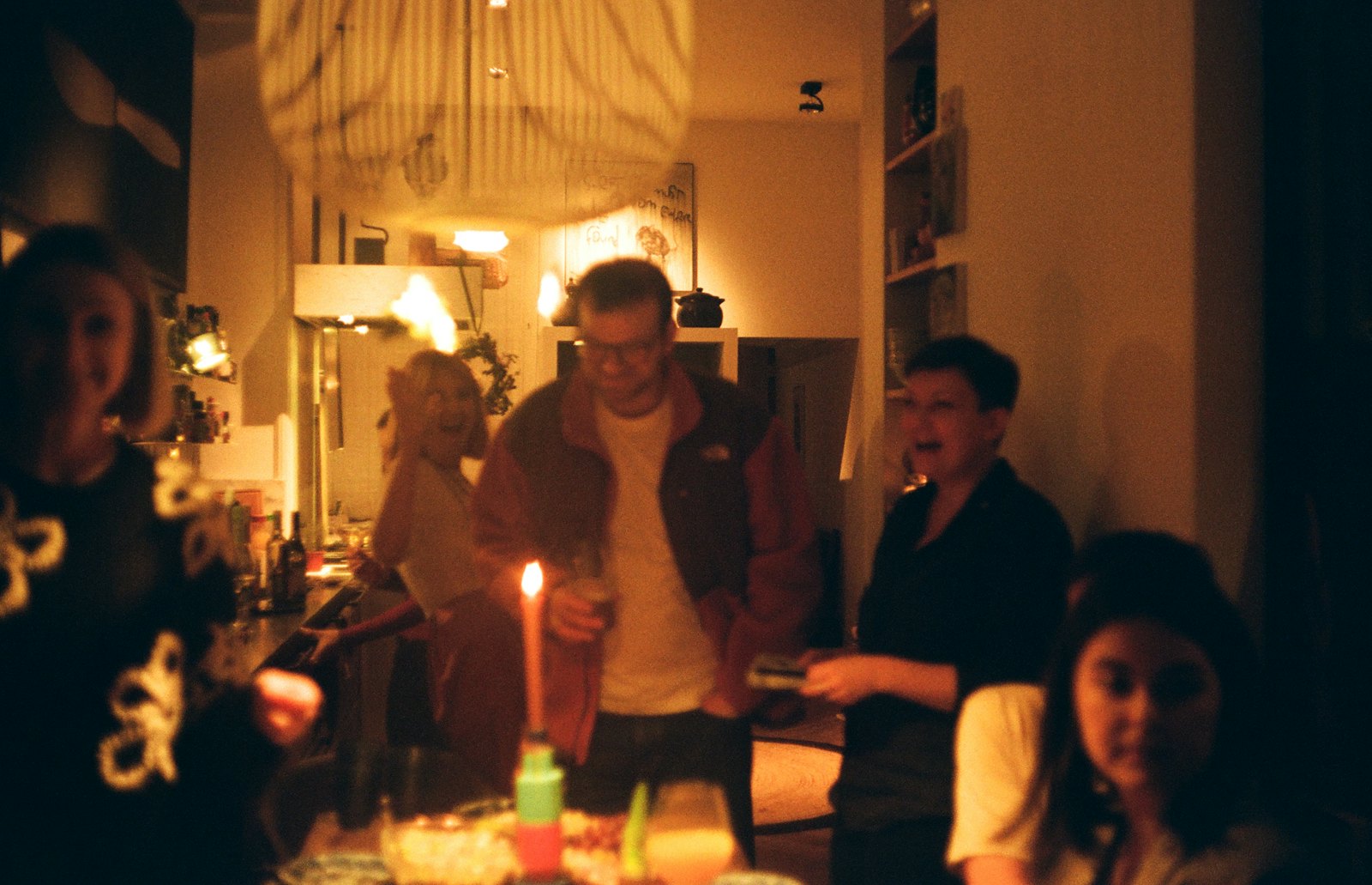 Freunde feiern abends bei Kerzenlicht in einer Wohnung