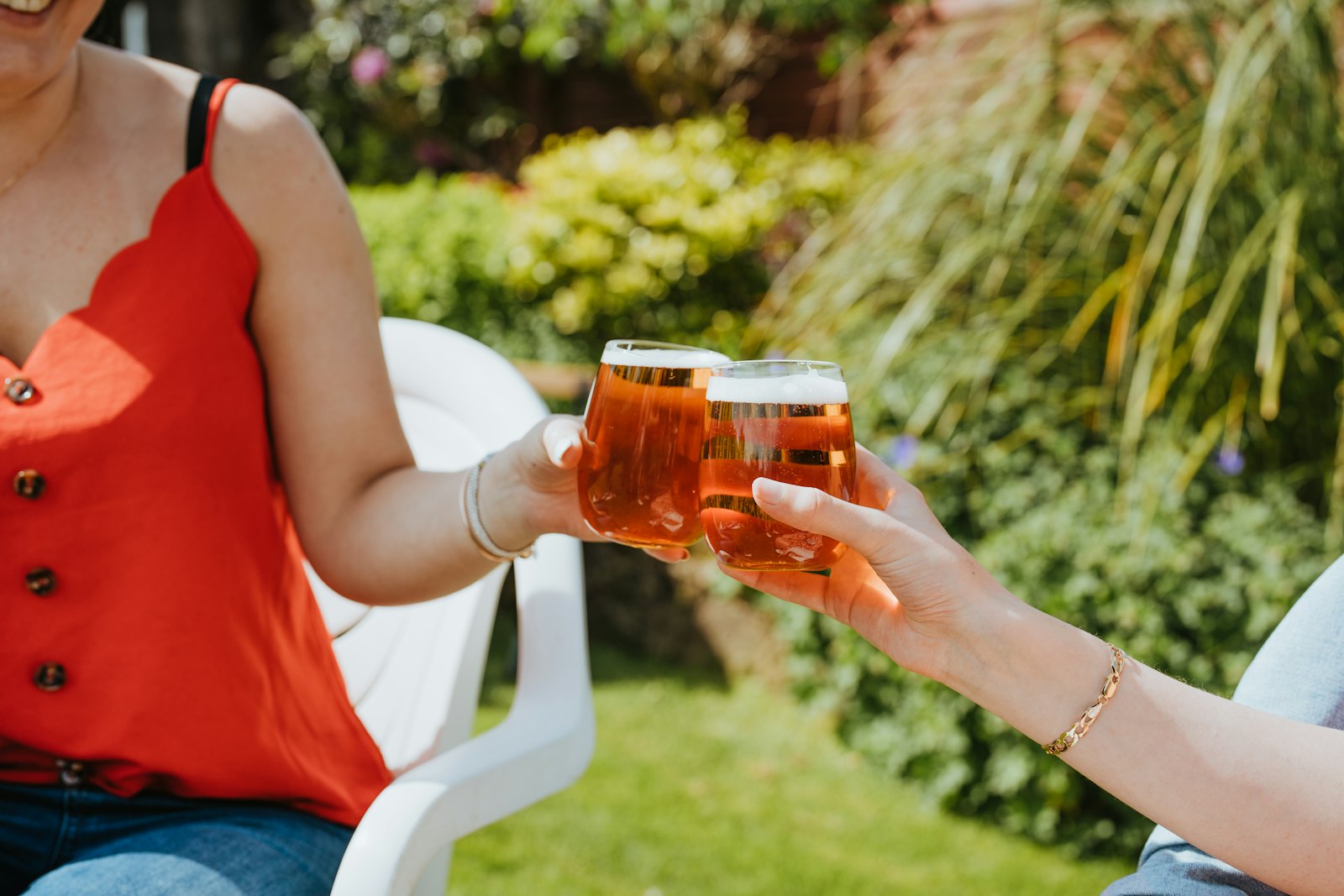 Zwei Freundinnen stoßen im Garten an